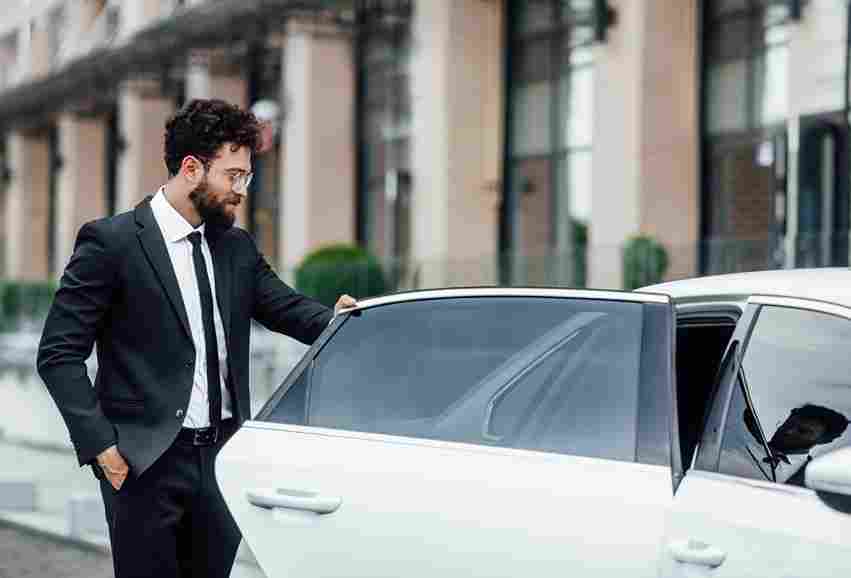 Person stepping out of a luxury car